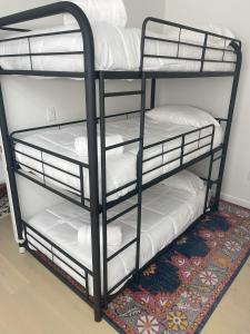 a black bunk bed with white pillows on it at Walk to Downtown UT Sports Famous Dining and abundant Nightlife from this Luxury Condo w 3 restaurants in the complex in Austin
