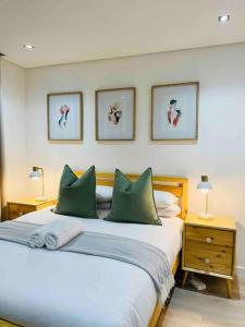ein Schlafzimmer mit einem großen Bett mit grünen Kissen in der Unterkunft Stylish Bree Street Apartment - The Perfect Urban Getaway in Kapstadt + 13 Fotos