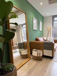 einen Spiegel in einem Zimmer mit einem Bett und einem Sofa in der Unterkunft Stylish Bree Street Apartment - The Perfect Urban Getaway in Kapstadt