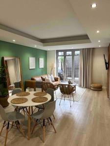 ein Wohnzimmer mit Tisch und Stühlen und einer Couch in der Unterkunft Stylish Bree Street Apartment - The Perfect Urban Getaway in Kapstadt