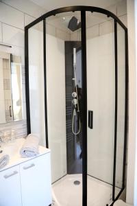 baño con ducha y puerta de cristal en MERCURE, en Saint-Quentin