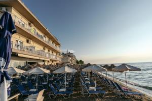 una fila de sillas y sombrillas en una playa en Hotel Galaxias en Paralia Katerinis