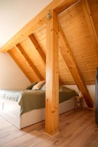a bed in a room with a wooden ceiling at Haus Jaeschke in Vetschau