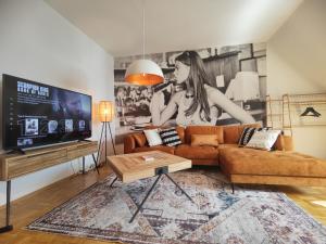 Maracoon - Suite Apartments Essen Messe I Great location في إيسن: غرفة معيشة مع أريكة وتلفزيون