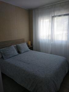 een slaapkamer met een groot bed en een raam bij Precioso Estudio in Sada