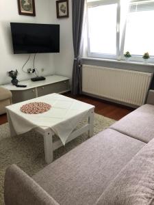 un soggiorno con tavolino e TV di Hava apartment a Sarajevo