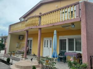 Casa con balcón y sombrilla azul en Guest House Oroshi, en Ulcinj