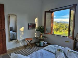 una camera con un letto e una grande finestra di Casita Icatá con vista a la montaña (A 5 minutos del pueblo) a Villa de Leyva