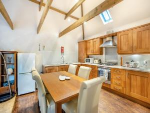 uma cozinha com uma mesa de madeira e electrodomésticos brancos em The Lodge - Uk44516 em North Thoresby