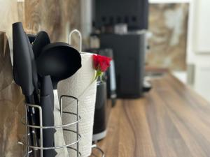 a container of kitchen utensils with a red rose in it at Ferienwohnung in Center of Hamburg-Barmbek-Airport-2 in Hamburg