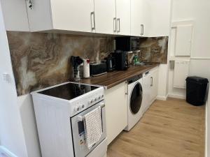 a kitchen with white cabinets and a washer and dryer at Ferienwohnung in Center of Hamburg-Barmbek-Airport-2 in Hamburg