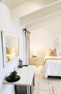 a white room with two beds and a mirror at Rest&Relax Guesthouse in Johannesburg
