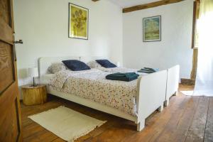una camera da letto con un letto bianco con cuscini blu di 1st Truffle House Žumberak a Ozalj