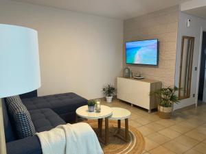 sala de estar con sofá y TV en la pared en Apartamento Kai, en Playa de Jandía