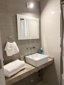 y baño con lavabo blanco y espejo. en 3-6 Hermoso Monoambiente baño privado en Buenos Aires