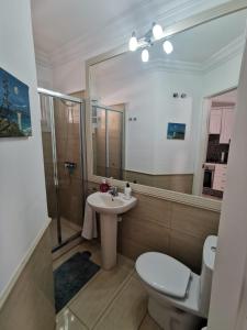 a bathroom with a sink and a toilet and a mirror at Relax and Enjoy in Tenerife Sud! in Chayofa
