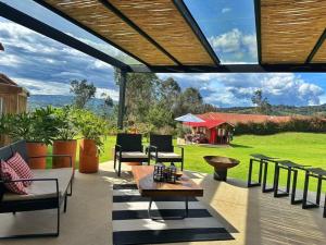 een patio met een tafel en stoelen en uitzicht bij Casa Araní - Vista espectacular y mucho jardín in Villa de Leyva
