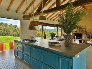 een keuken met blauwe kasten en een aanrecht bij Casa Araní - Vista espectacular y mucho jardín in Villa de Leyva