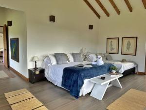 een slaapkamer met een groot bed en een tafel bij Casa Araní - Vista espectacular y mucho jardín in Villa de Leyva
