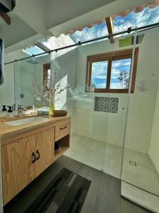 een badkamer met een douche, een wastafel en een spiegel bij Casa Araní - Vista espectacular y mucho jardín in Villa de Leyva