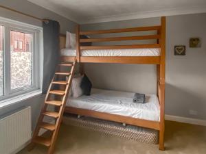 two bunk beds in a room with a ladder at Sea View Cottage in Llandrillo-yn-Rhôs