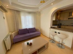 - un salon avec un canapé violet et une table dans l'établissement Family 2bd Flat 150m to the Beach, à Alanya