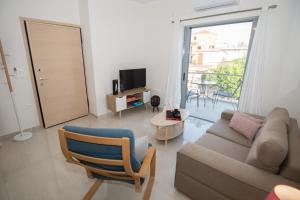 a living room with a couch and a tv at Vonitsa Luxury Apartments in Vonitsa