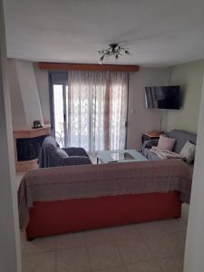 een woonkamer met een bank en een tafel bij Dominikis appartment in Néa Péramos
