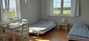 a bedroom with a bed and a desk and two windows at Kwatery Mielenko Patraj in Mielenko