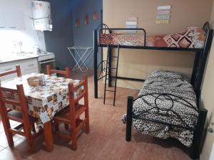 a room with two bunk beds and a table and chairs at Linda vista in Arroyo de Los Patos