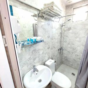 Un baño blanco con lavabo e inodoro. en Dodo-Inga's Apartment, en Tiflis 6 fotos más