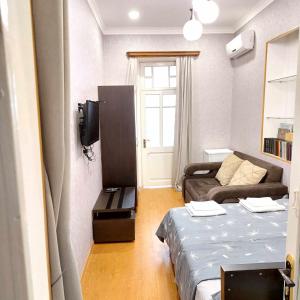 una pequeña habitación con una cama y un sofá en Dodo-Inga's Apartment, en Tiflis