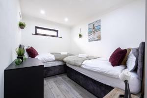 a bedroom with a large bed with purple pillows at 7 Guests - 4 Bedroom - Free Wi-Fi - Kettering in Kettering