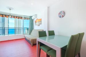 sala de estar con mesa, sillas y ventana en Ducado 10-J Apartment Levante Beach, en Benidorm