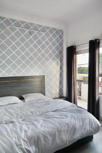 a bedroom with a bed with a blue and white wall at Aarambh Residency in Khajurāho