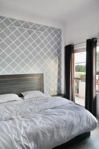 Un dormitorio con una cama con una pared azul y blanca en Aarambh Residency en Khajurāho
