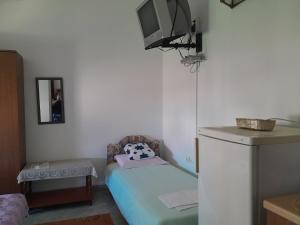 Habitación pequeña con cama y TV. en Guest House Oroshi, en Ulcinj