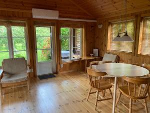 - une salle à manger avec une table, des chaises et des fenêtres dans l'établissement Golden Seaside Villa, à Kärdla