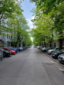een lege straat met auto's aan de zijkanten van de weg bij Room 23 in Belgrado