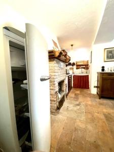 sala de estar con chimenea de piedra en la cocina en La Dimora Degli Olivi, en Galbiate
