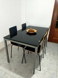 una mesa de comedor negra y sillas con un plato. en Boa Vista, en Monforte de Lemos