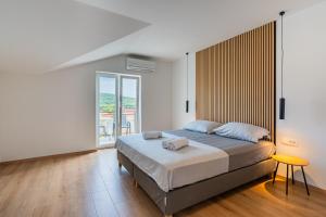 a bedroom with a bed and a large window at Apartments & Rooms Klemenc in Cres