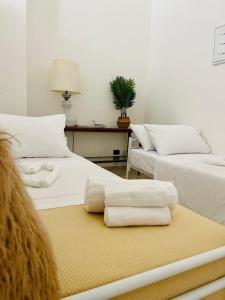 a room with two beds with towels on a table at wild rooms&house in Nettuno