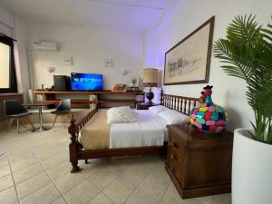 a bedroom with a bed and a desk with a tv at wild rooms&house in Nettuno