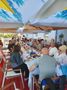 a group of people sitting at tables under a tent at Pensiune Runcu Stone in Runcu