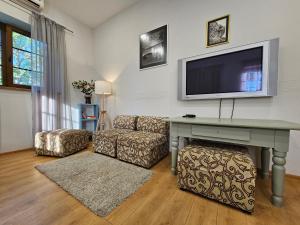 ein Wohnzimmer mit Sofa und Fernseher an der Wand in der Unterkunft Sodyba Pakrantė in Dituva