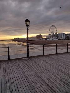 a light pole on a pier with a ferris wheel at Cute Studio with kitchen, patio and free parking in Worthing