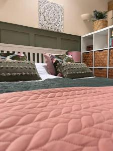 1 Schlafzimmer mit 2 Betten und einer rosa Decke in der Unterkunft Cute Studio with kitchen, patio and free parking in Worthing