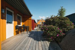 una terraza de madera con flores en una casa en Hvasser Motell, en Hvasser