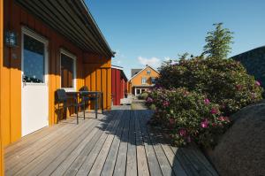 a wooden deck with flowers on a house at Hvasser Motell in Hvasser +12 photos